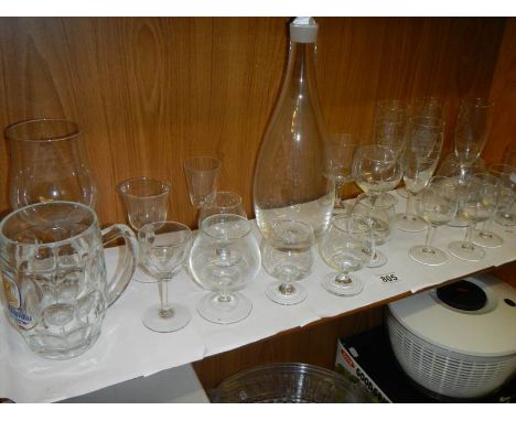 A decanter and a quantity of glasses.