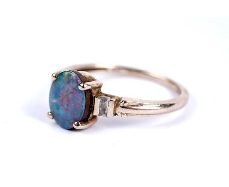 An opal doublet dress ring, the oval opal flanked by baguette cut white sapphires, in 9ct yellow gold, size N 1/2, 2.2g gross