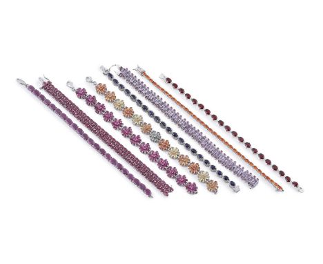 A collection of gemstone set bracelets, including: a garnet line bracelet; a fire opal line bracelet; a ruby line bracelet; a