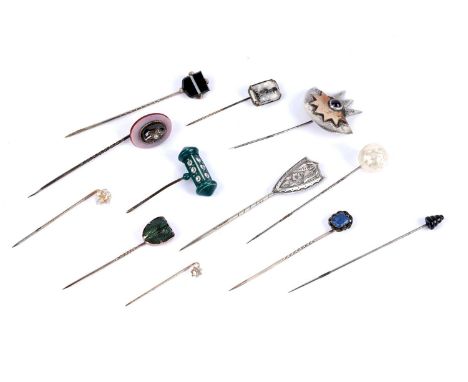 A selection of antique stick pins, including: a Victorian star set seed pearl, garnet and chalcedony stick pin; an Egyptian R