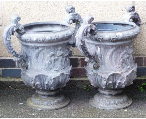 A pair of lead twin handled garden urns, with leaf scroll handles, the body decorated with a frieze of classical figures, 63c