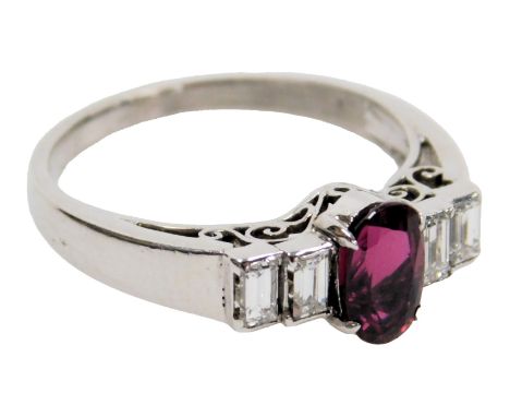 A 14ct white gold, corundum and diamond ring, set with an oval cut central corundum flanked by four emerald cut diamonds, cor