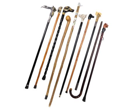 A group of walking sticks, including four with dog's head handles, another surmounted with a bird, and a stick with a dragon 