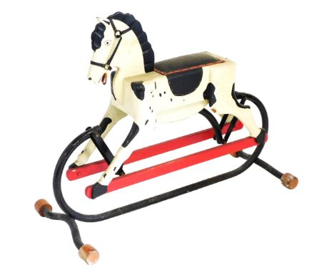 A 20thC carved wooden rocking horse, on a cast iron frame, with leather saddle, 105cm wide.