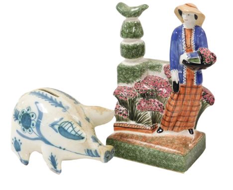 A 20thC Rye pottery figure of The Country Gardener, printed mark, 25cm high together with a Rye pottery piggy bank, painted i