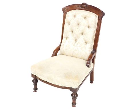 A Victorian mahogany nursing chair, upholstered in cream floral button back upholstery, raised on turned legs, on castors, 63