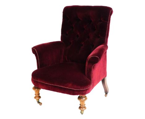 A Victorian mahogany nursing chair, upholstered in red button back fabric, raised on turned legs, brass capped on castors, 80