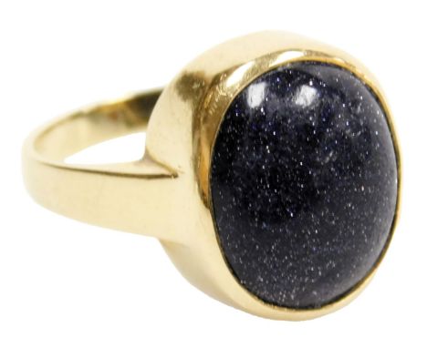 A blue goldstone cabochon ring, set in yellow metal, stamped 18ct, size S, 7.8g.