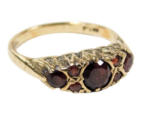 A 9ct gold and garnet set ring, with three principle garnets flanked by two pairs of smaller garnets, size N, 2.9g.