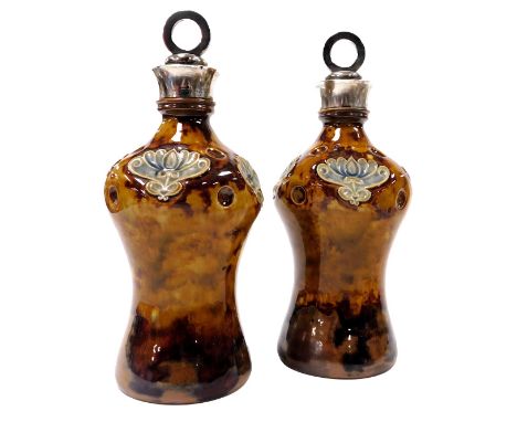 A pair of early 20thC Doulton Lambeth stoneware bottles, with stoppers and silver mount, the stoppers with circular ring tops