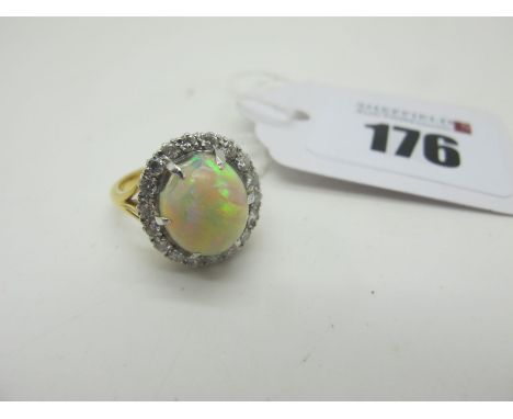 An Opal and Diamond Cluster Ring, the high oval cabochon opal (chipped) claw set, within claw set border of brilliant cut dia