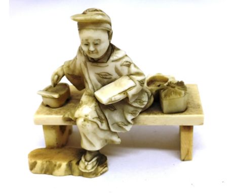 A Meiji Period Ivory Carving:In the form of a Scholar sitting with leg underneath him on a bench, writing on parchment.Height