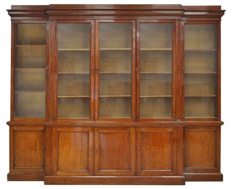 A Bookcase:19th century, mahogany, breakfront, the five glazed doors opening to reveal a three shelf arrangement above 5 pane