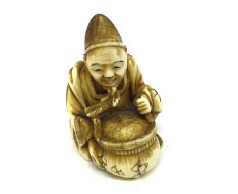 A Meiji Period Ivory Netsuke:In the form of a seated man in a robe and hat holding a Censer.Height 4 cm   CONDITION REPORT:  