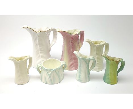 A group of six Royal Worcester leaf moulded porcelain jugs, largest with pink toned glaze, H17.5cm, plus a similarly modelled