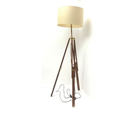 A mahogany and brass mounted tripod standard lamp, with retractable feet, and accompanying cream shade, lamp base when extend