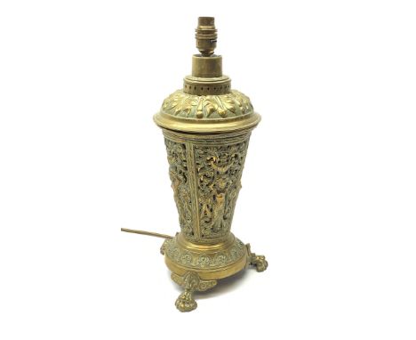 A brass table lamp, of tapering form, the pierced body detailed with stylised classical figures within a scrolling surround, 