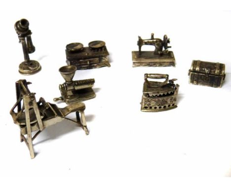A collection of sterling silver minature models including a sewing machine, scales, a telephone, an iron and a chest etc. No 