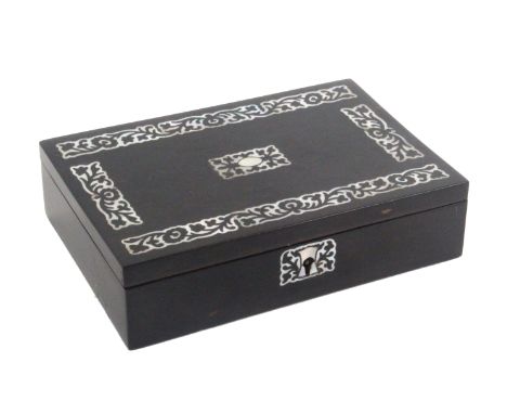 An early Victorian fitted sewing box of small rectangular form, veneered in ebony with cut mother of pearl escutcheon, the li