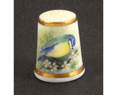 A Royal Worcester black mark thimble, painted with a blue tit on a flowering branch and a further flowering branch between gi
