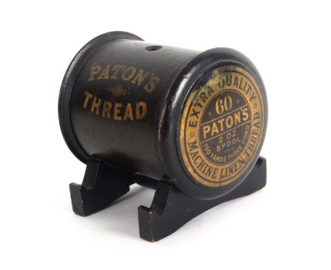 A rare Paton's Thread advertising counter string box, in the form of an ebonised oversized reel inscribed in gilt twice 'Pato