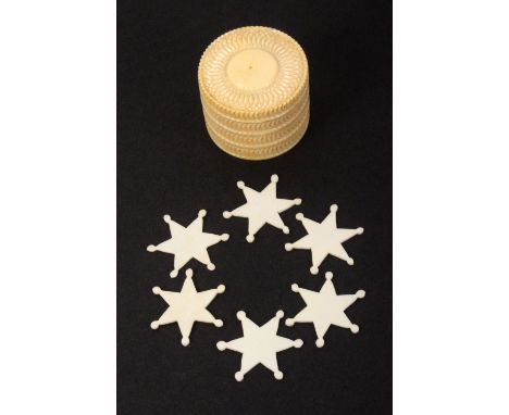 A set of six 19th Century ivory thread winders, of star form, 2.7cms, contained in a turned ivory box with engine turned deco