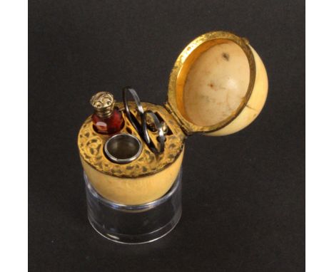 A mid 19th Century ivory egg form etui, the hinged lid over a leaf scroll engraved gilt tool mount with ruby glass scent bott