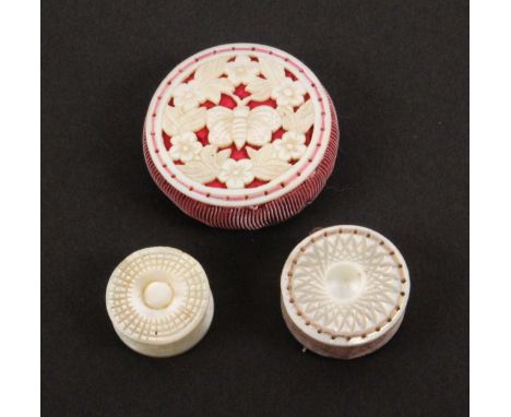 A mother of pearl pin cushion, an emery and a waxer, all of disc form the pin cushion pierced and carved with flowers and lea