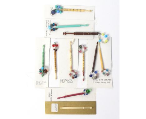 Eleven various lace bobbins, comprising / a wood and a bone example with evil eye beads / a pewter spot decorated example wit