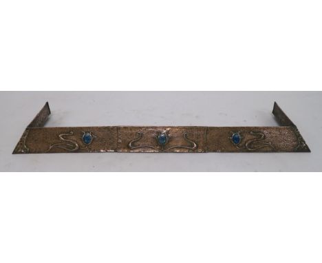 AN ARTS AND CRAFTS HAMMERED COPPER FENDER  with sinous foliage and inset with ceramic medallions, 12cm high, 156cmm wide and 