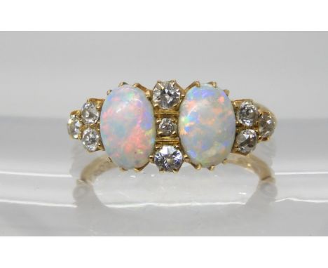 AN OPAL AND DIAMOND CLUSTER RING  set with two opals of approx dimensions 7.6mm x 5.2mm, with a trio of old cuts to the shoul