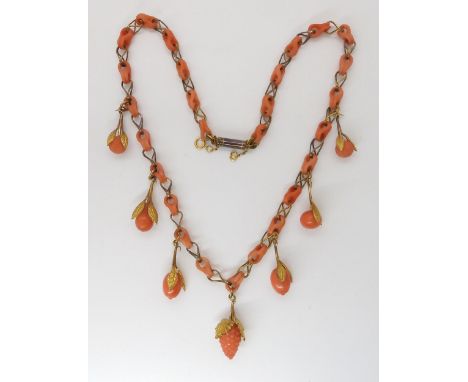 A CARVED CORAL FRUIT NECKLACE the fruit mounted with engraved and chased yellow metal leaves, with coral chain links to yello