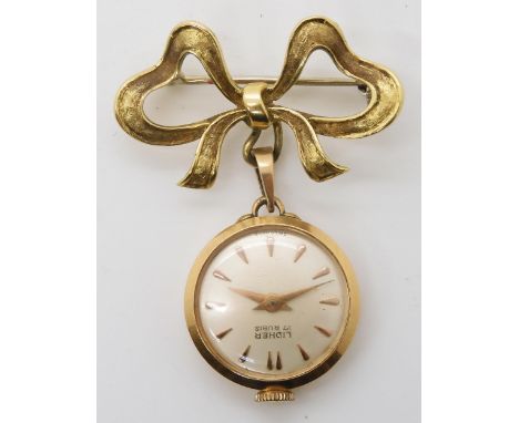 A LADIES 18K GOLD LIDHER FOB WATCH&nbsp; with 18k gold bow brooch attached. The white dial with copper coloured chevron numer