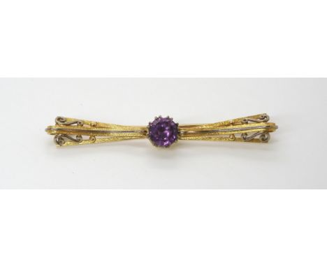 AN 18CT GOLD TWO COLOUR GOLD BROOCH  craftsman made and set with a colour change faux amethyst. Length 7.2cm, weight 10.9gms 