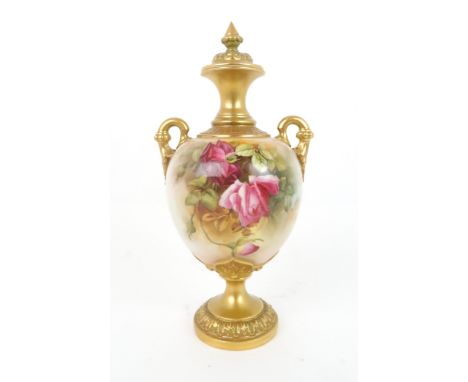 A ROYAL WORCESTER URN AND COVER  decorated with roses and foliage, with gilded handles, neck and base, date mark for 1917, un