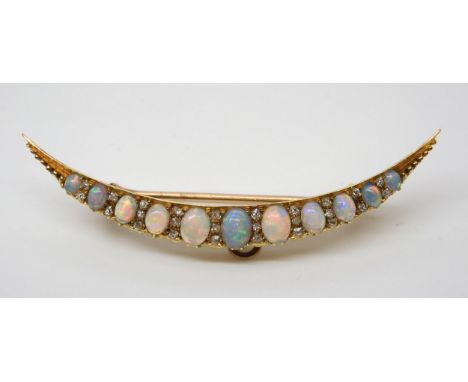 AN OPAL AND OLD CUT DIAMOND CRESCENT MOON BROOCH  hand made in bright yellow metal, set with eleven lively cabochon opals wit