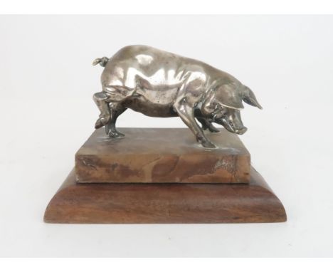 A WHITE-METAL MODEL OF A PIG on hardwood base and on oak base with plaque, inscribed "Oak From Orlop Deck of HMS Victory, Giv