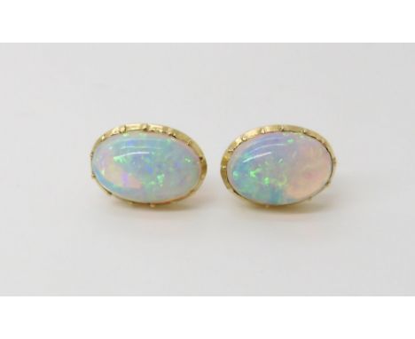 A PAIR OF JELLY OPAL EAR STUDS  dimensions of the opals 10.5mm x 7.5mm, in yelow metal cut back mounts with post and butterfl