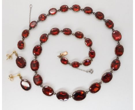 AN ANTIQUE FOILED BACK GARNET PARURE comprising of a necklace the garnets in  yellow metal cut back settings, with matching e