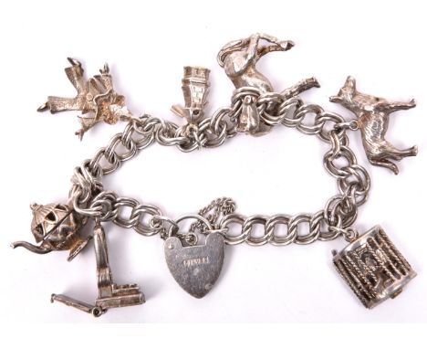 A silver coloured charm bracelet, double link chain, with tiny stage and 3 dancing girls with movable kick up legs, Alsatian 