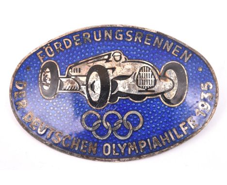A Third Reich oval silver plated and blue enamel pin back badge, depicting an Auto Union racing car over the Olympic emblem a