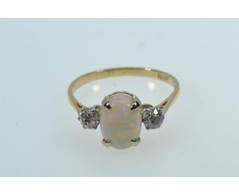 18ct gold ring with an oval cabochon opal in a yellow claw setting, flanked by round brilliant cut diamonds in platinum claw 