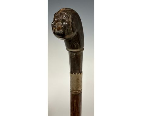 A carved horn handled walking stick, as a bald mans head, inset glass eyes, metal ferule, banded tapering shaft, 86cm long. 