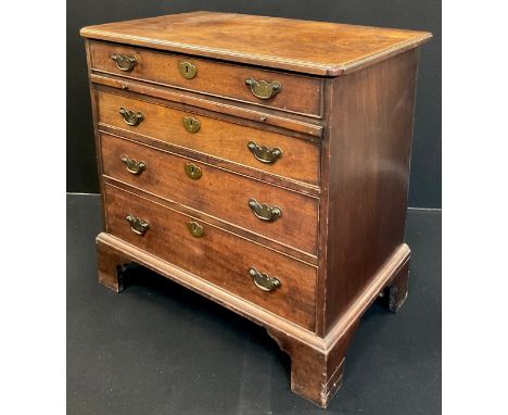 A George III mahogany bachelor’s chest, the hinged top lifting to reveal a partitioned recess with mirror above, and draw-out
