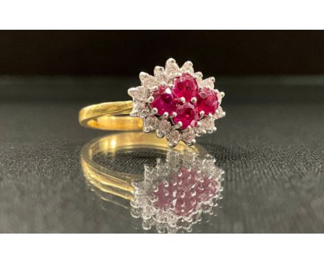A ruby and diamond cluster ring, with four pinky red round cut diamonds, surrounded by sixteen round brilliant cut diamonds, 