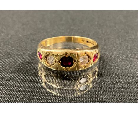 A diamond and ruby ring, set with three graduated red rubies, divided by round brilliant cut diamonds, total estimated stone 