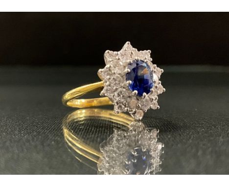 A sapphire and diamond ring, central oval strong blue sapphire, approx 0.75ct, surrounded by a ten point double layer halo of