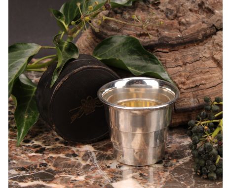An early 20th century silver plated collapsible travelling beaker or stirrup cup, 6cm high, the morocco case tooled and gilt 