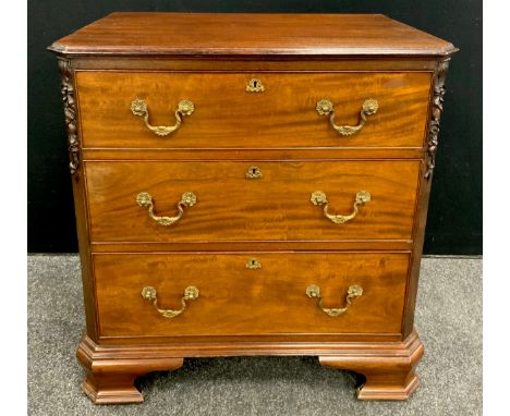 A George III revival mahogany small chest of drawers, the slightly over-sailing top, with canted corners carved with ribbons 