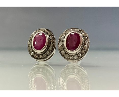 A pair of diamond and ruby earrings, central collar set oval ruby surrounded by a halo of rose cut diamonds, total estimated 